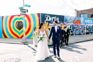 bridal party walking in front of mural